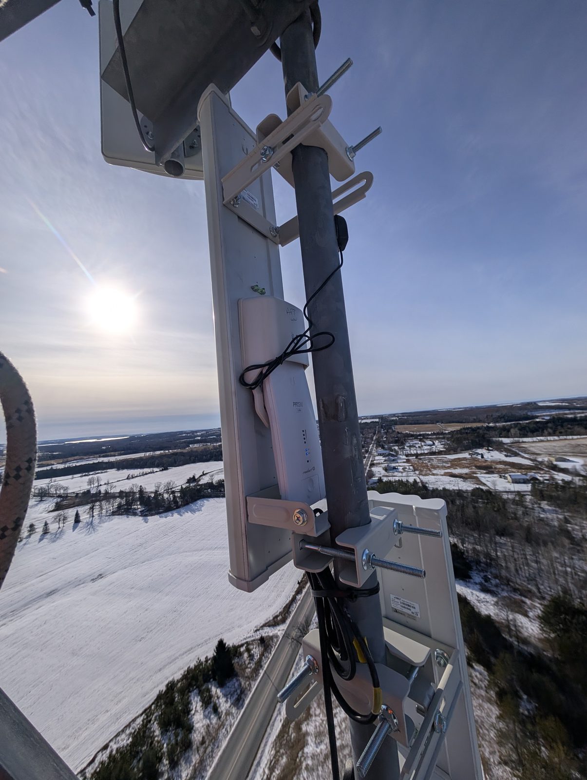 Broadband panel install on a tower above a snowy landscape